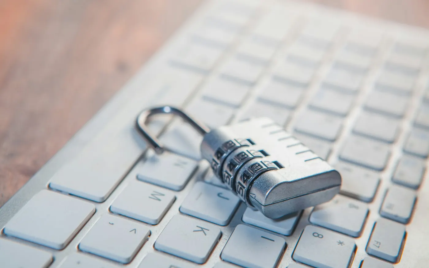 A combination padlock resting on a laptop keyboard