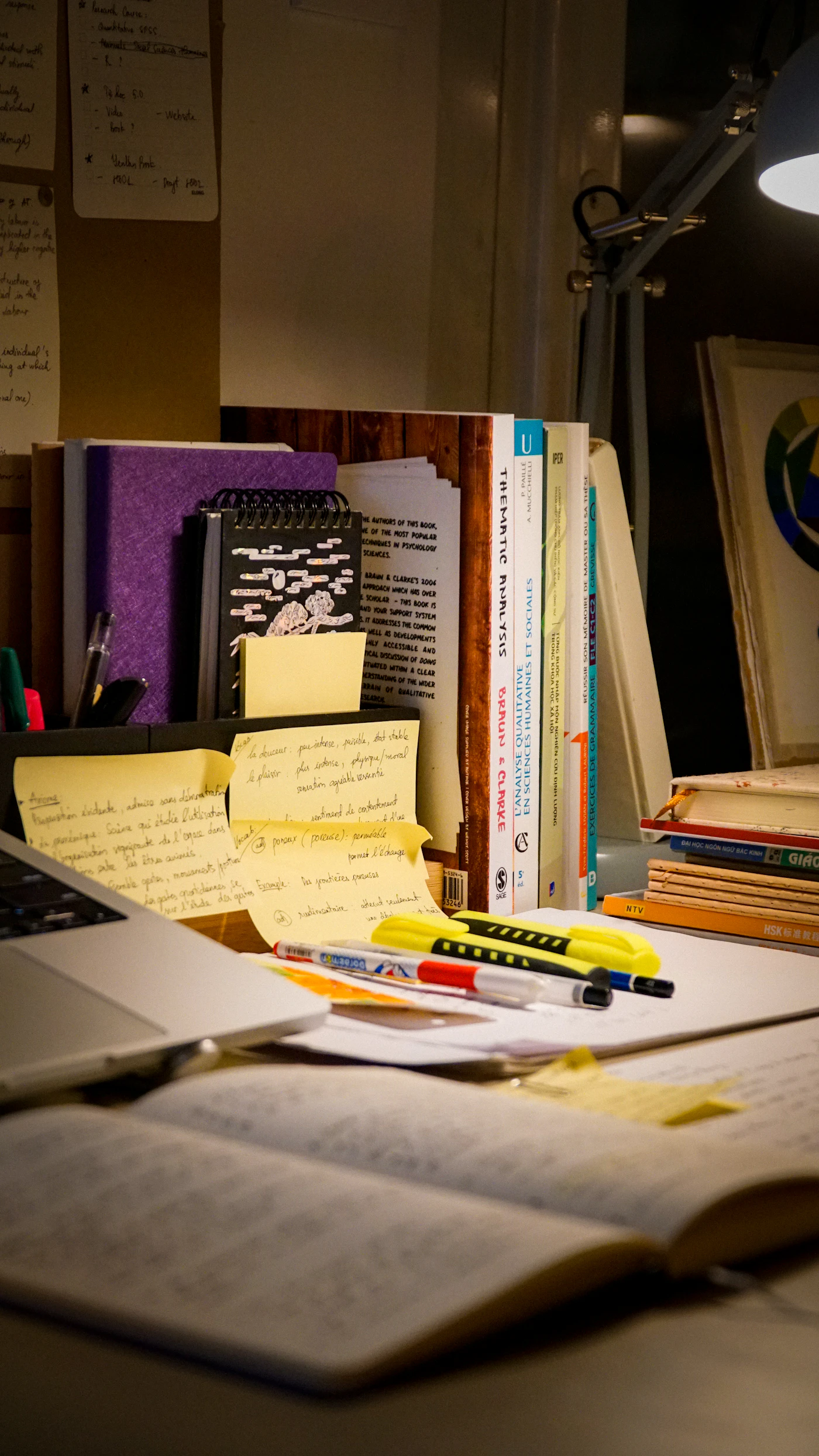 Books, notes and a laptop arranged on a study desk